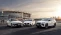 Drei weiße Hyundai Fahrzeuge parken in Frontalansicht vor einem Stadion.