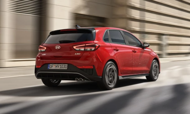 Roter Hyundai Kleinwagen in Heckansicht fährt sehr dynamisch.