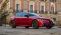 Ein roter Alfa Romeo parkt auf einem Platz.