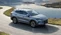 BYD-SUV fährt vor Berg- und Seepanorama.
