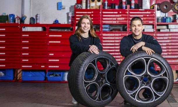 Zwei Werkstatt-Mitarbeiter hocken vor zwei Leichtmetall-Felgen in der Kummich-Werkstatt.