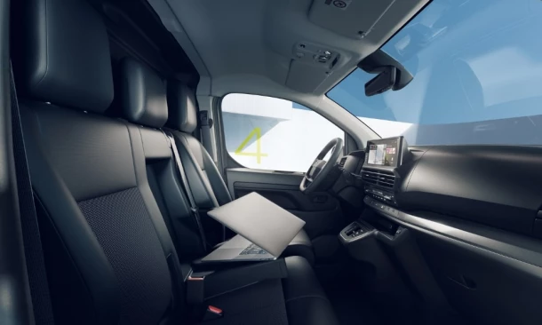 Geräumiges Cockpit eines modernen Transporters mit digitalem Display und multifunktionalem Beifahrersitz.