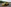 Seitenaufnahme eines gelben Fiat SUVs mit Wald im Hintergrund.