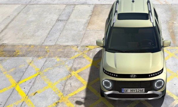 Parkender Hyundai City- SUV in buttergelb aus der Vogelperspektive von vorne.